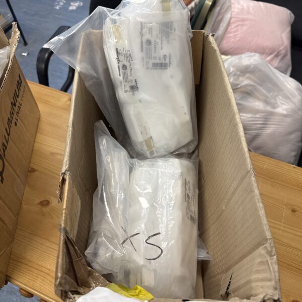 Stack of fifteen Global Industrial xts24-3 shop light fittings in packaging.