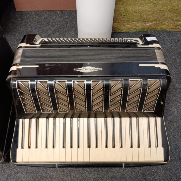 Vintage Rauner accordion with mother-of-pearl keys and dark wood finish.