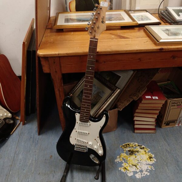 Black Power Play electric guitar on a wooden surface.
