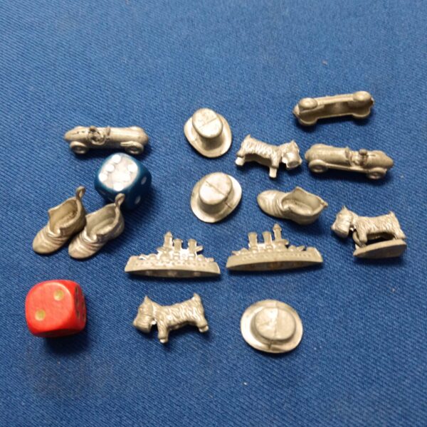 Vintage metal Monopoly pieces including a car and battleship.