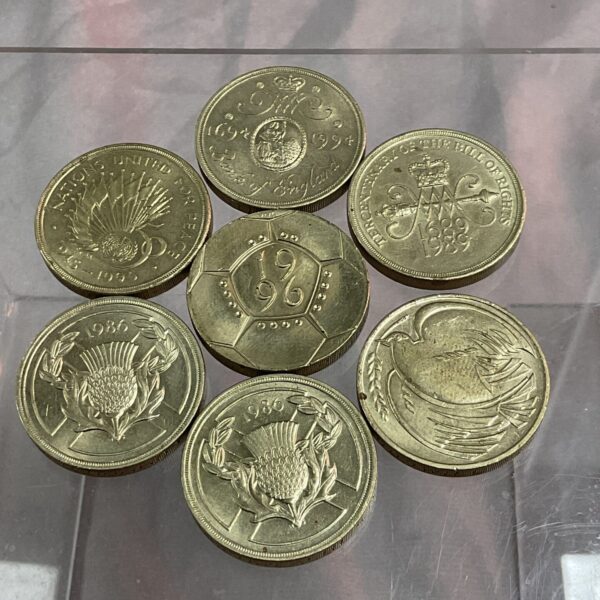 Pile of seven UK £2 coins for collectors.