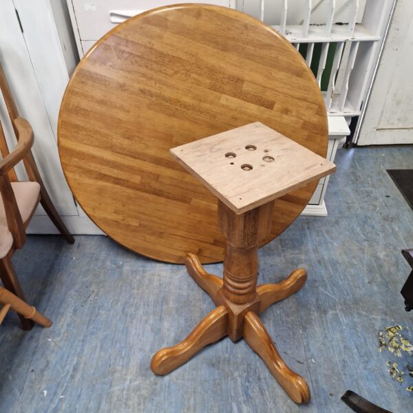 Round wooden table with pedestal base, vintage style.