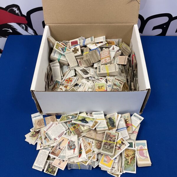 Large collection of vintage John Player cigarette cards in a cardboard box.