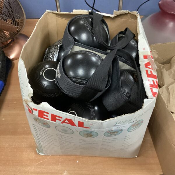 Four sets of used garden bowls in a cardboard box.