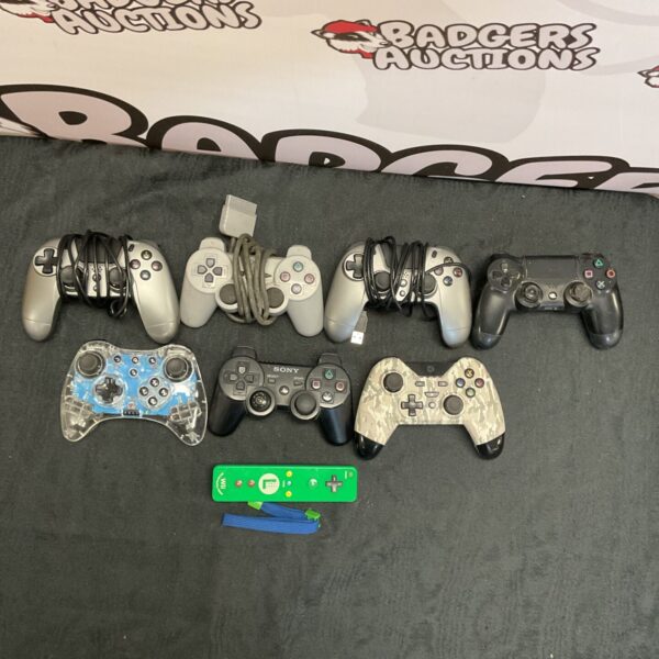 Mixed lot of vintage and modern game controllers for various consoles.