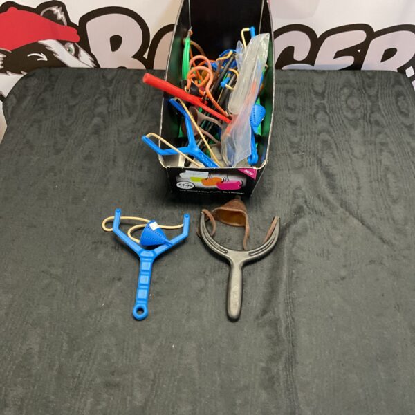 Lot of colourful plastic toy catapults for children's play.
