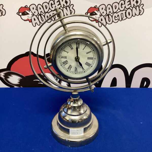 Vintage chrome swivel clock with black numerals on white face.