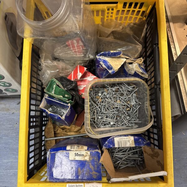Crate filled with assorted nails and tacks for DIY projects.