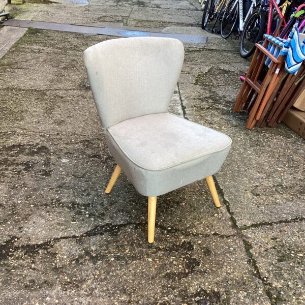 Grey upholstered designer chair with wooden legs.