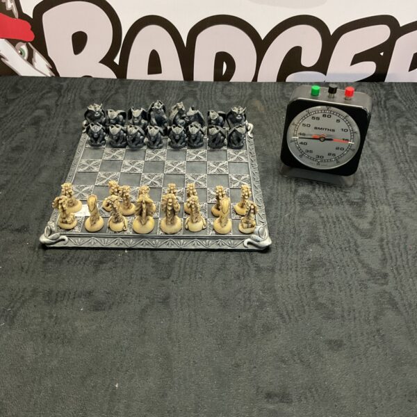 Detailed dragon and gargoyle chess set with vintage Smiths timer.