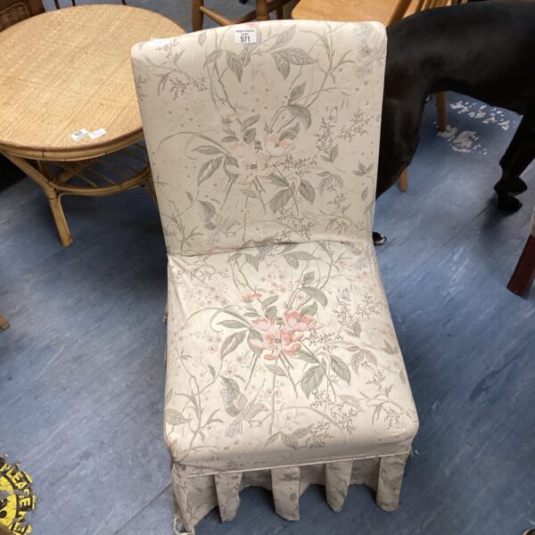 Vintage floral nursing chair with patterned upholstery.
