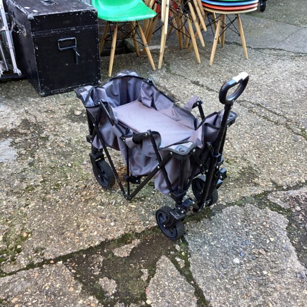 Collapsed folding garden trolley with metal frame.