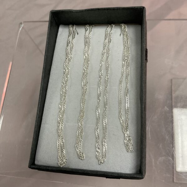 Four delicate 925 silver chain necklaces displayed in a box.