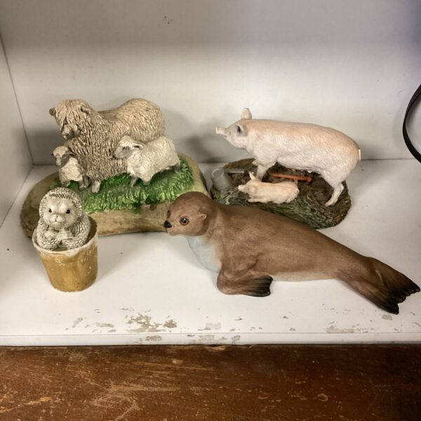 Collection of vintage animal figurines including sheep and pigs.