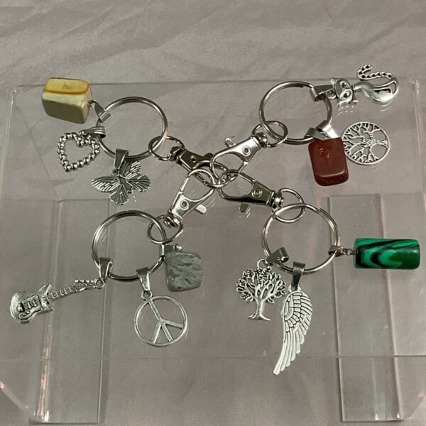 Set of four crystal keyrings with various charms.