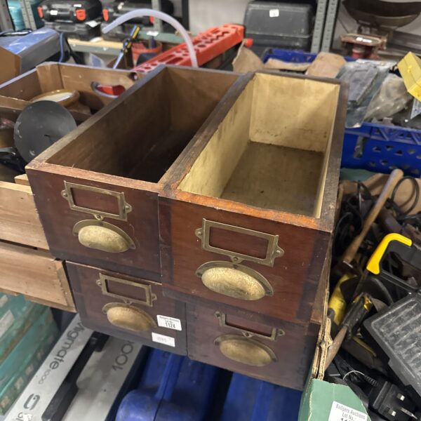 Vintage wooden filing drawers with brass handles for office storage.