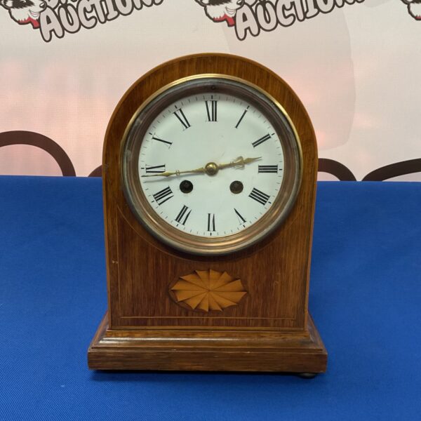 Antique French mantle clock with detailed wooden case.
