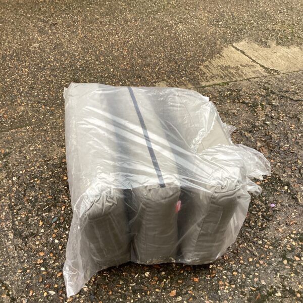 Close-up of grey garden seat cushions, showing texture and plastic wrap.