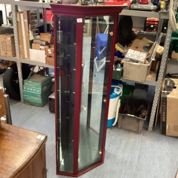 Vintage corner display cabinet with glass panels and lighting.