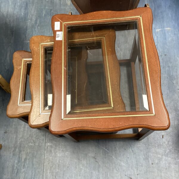 Vintage mahogany nest of tables with glass tops in a living room setting.