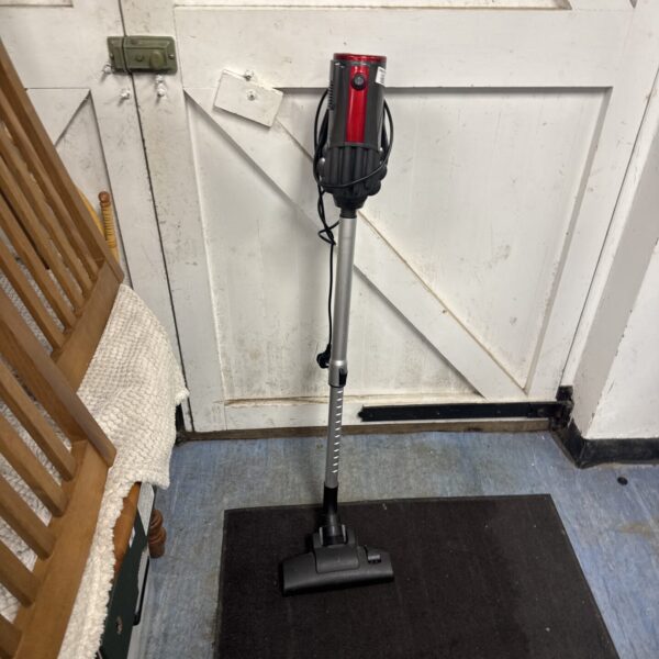 Upright Goodmans corded vacuum cleaner on a dark floor.