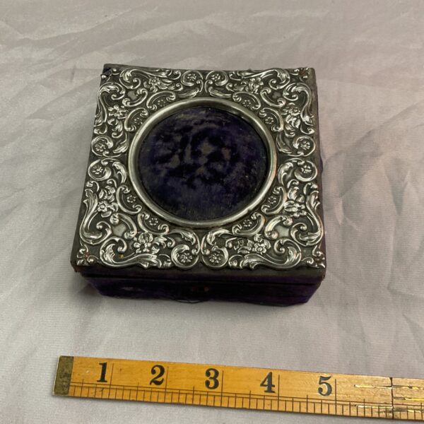 Antique silver pin cushion box with velvet lining and floral design.