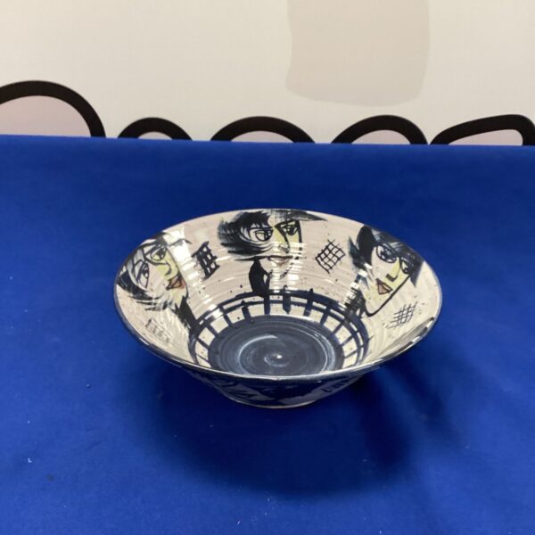 Unique handcrafted glazed bowl with dark imagery.