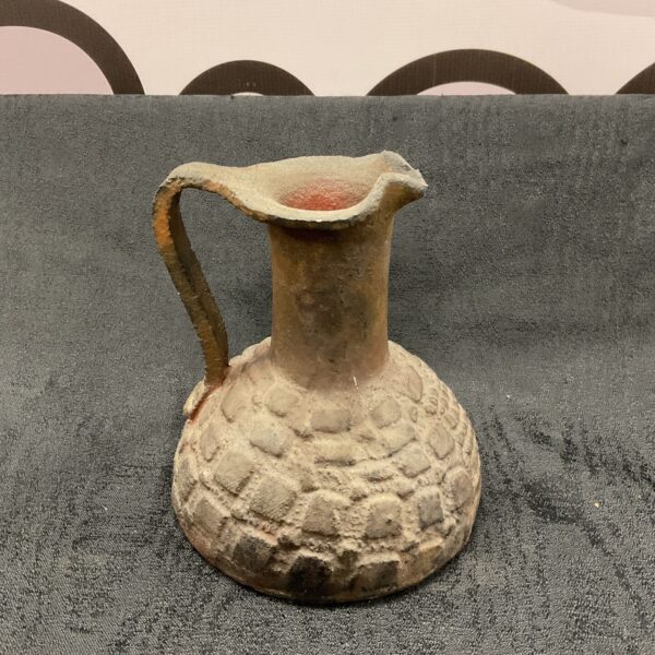 Rustic studio pottery jug with a unique textured surface.