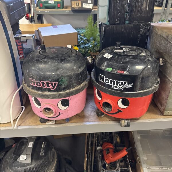Red and pink Numatic Henry and Hetty Hoover bodies for restoration.