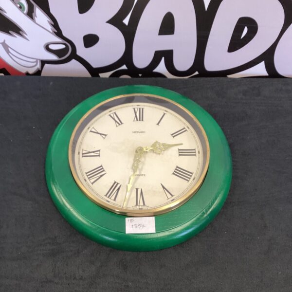 Vintage green Metamec quartz wall clock with black hour markers.