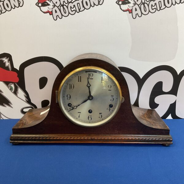Vintage German mantle clock with Westminster chime on wooden base.