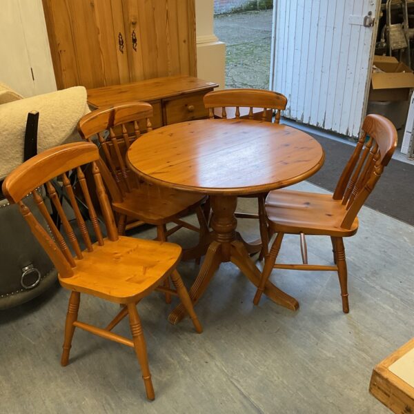 Rustic pine kitchen table and four chairs in a farmhouse setting.