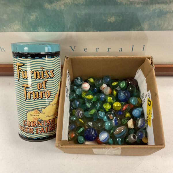 Vintage tin filled with colourful glass marbles for collectors.