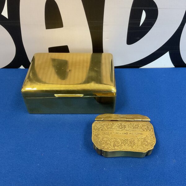 Antique brass cigarette and snuff boxes with embossed detailing.