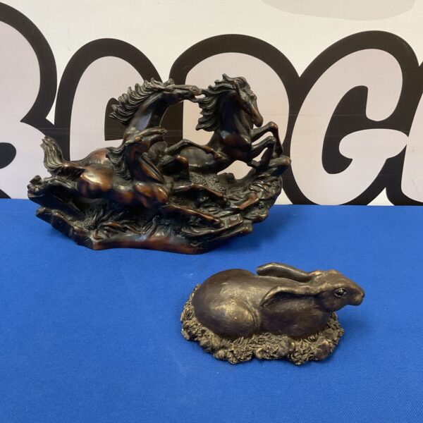 Dynamic bronzed horse sculpture with three horses galloping.