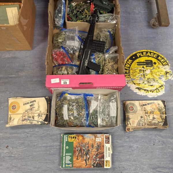 Assorted vintage model kits and toy soldiers in a cardboard box.
