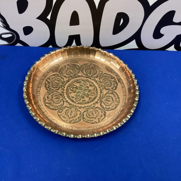 Vintage hammered copper dish with intricate Arts and Crafts detailing.