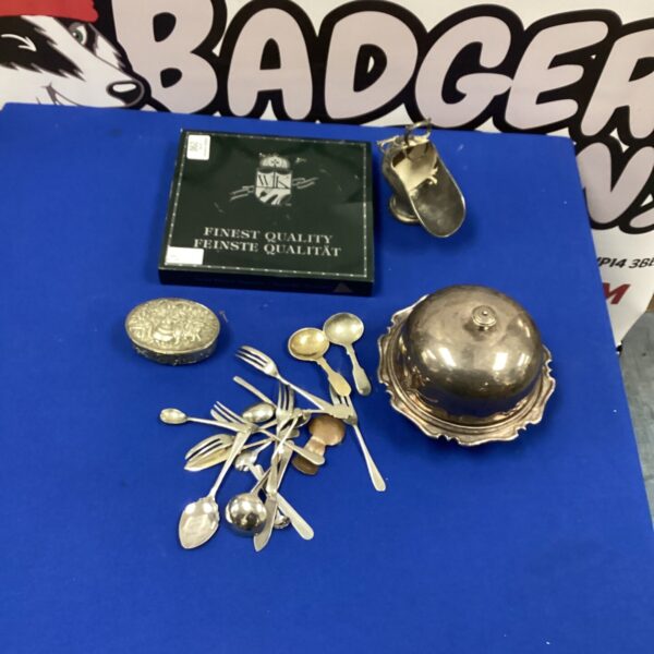Vintage silverplate trinket box and cutlery set on display.