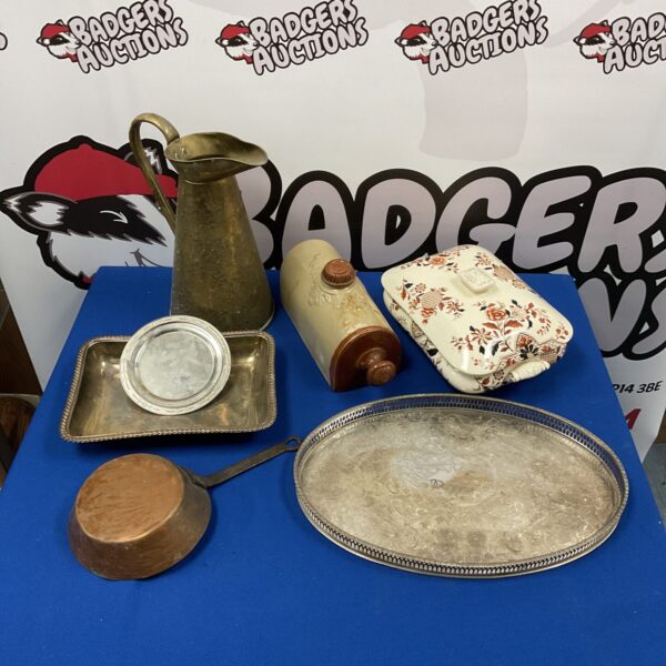 Vintage silver plate serving tray and brass pitcher on display.