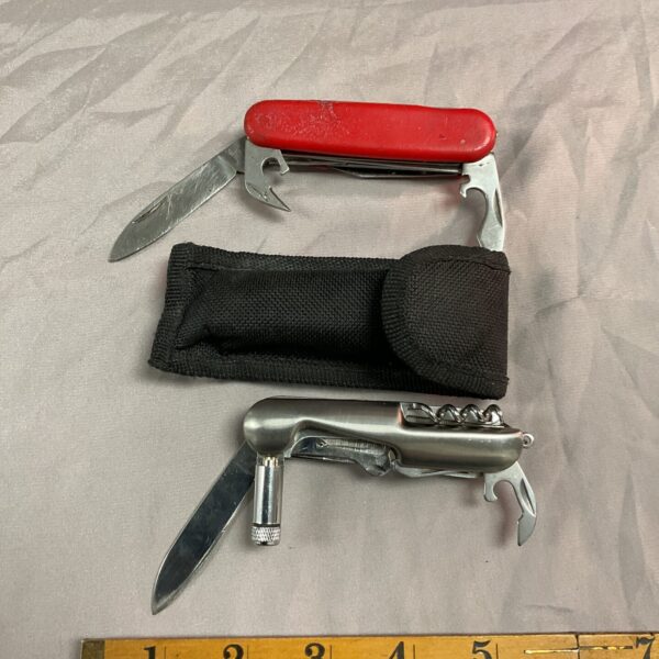 Vintage pocket knife with multiple tools, stainless steel blade.