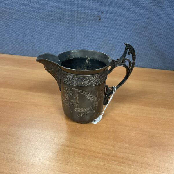 Antique pewter cream jug by Barbour Bros, detailed embossed design.