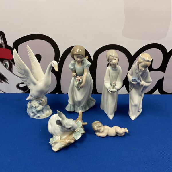 Lladro and Nao porcelain ornament collection featuring cherub and swan.