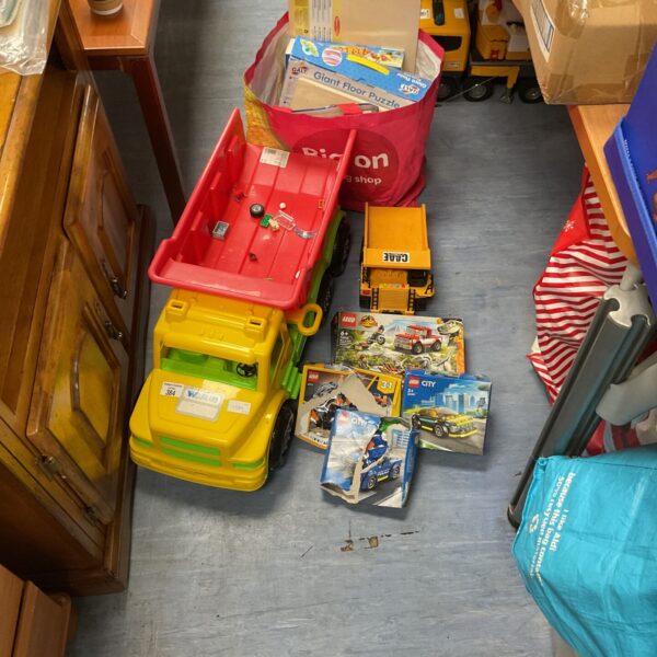 Brightly coloured toy trucks and Lego sets in a mixed toy lot.