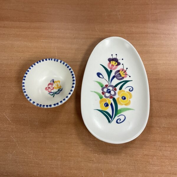 Vintage Poole Pottery trinket set with floral design on wooden surface.