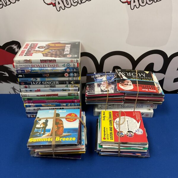Mixed lot of DVDs, CDs, and VHS tapes for home entertainment.