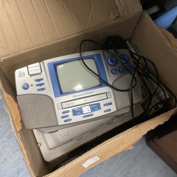 Vintage Singing Machine karaoke system with cassette player and microphone.