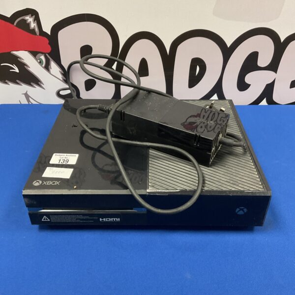 Black Xbox One console with power supply for gaming and entertainment.