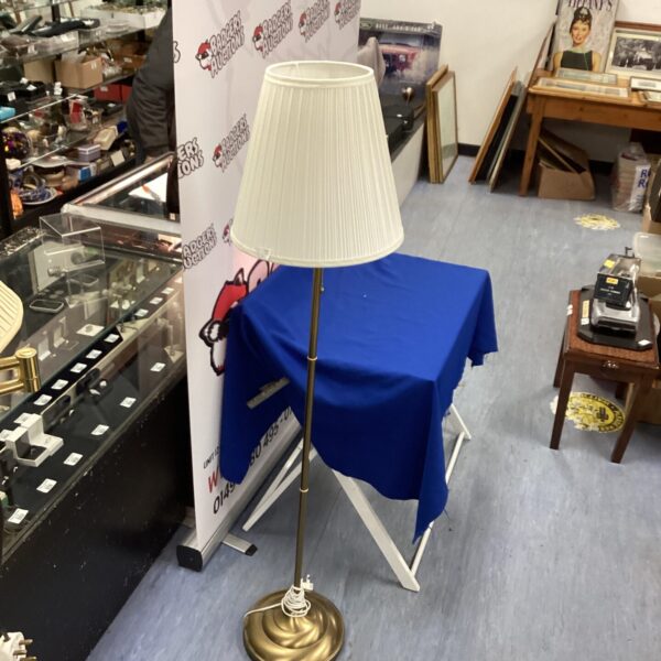 Tall brushed brass standard lamp with cream shade.
