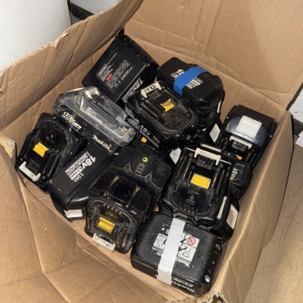Untested Makita cordless tool batteries in a cardboard box.
