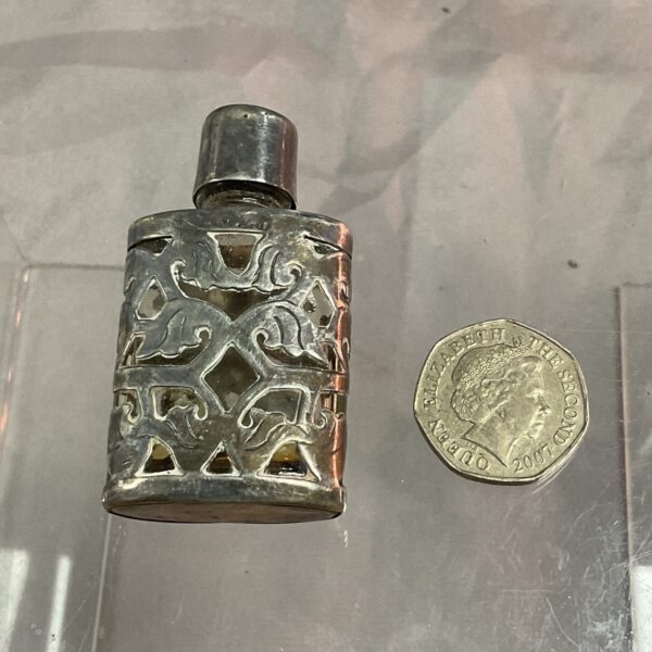 Antique silver scent bottle with intricate Victorian detailing.